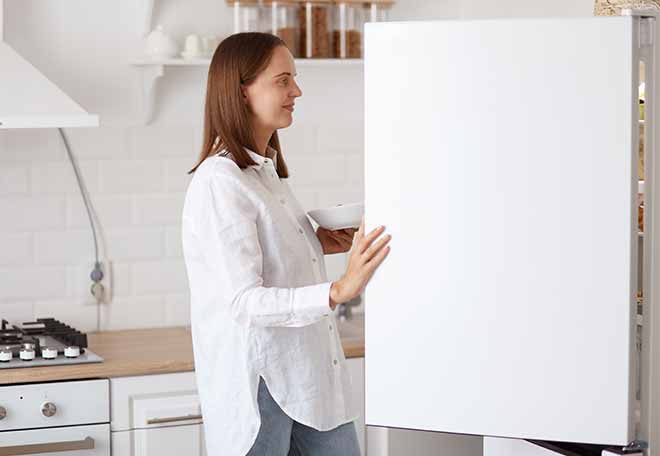 profile-portrait-beautiful-young-adult-woman-wearing-white-shirt-looking-smiling-inside-fridge-with-pleasant-smile-holding-plate-hands-posing-with-kitchen-set-background.jpg